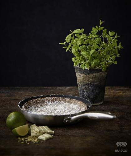 Tytanowo-ceramiczna patelnia Scanpan CTX na blacie z limonką i miętą