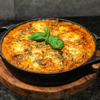 Skeppshult Traditional - żeliwna patelnia z bukowym uchwytem, Ø 28 cm, danie z serem i bazylią.