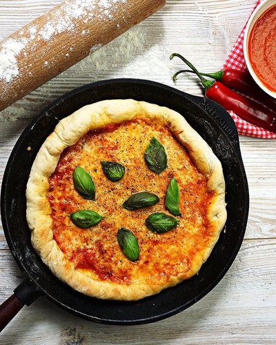 Żeliwna patelnia Skeppshult Walnut z pizzą i uchwytem z orzecha włoskiego.