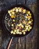 Żeliwna patelnia Skeppshult Walnut z uchwytem z orzecha, smażone gnocchi, rustykalne tło.
