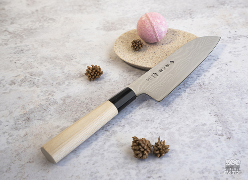 Japoński nóż Santoku Tojiro Shippu na tle dekoracji