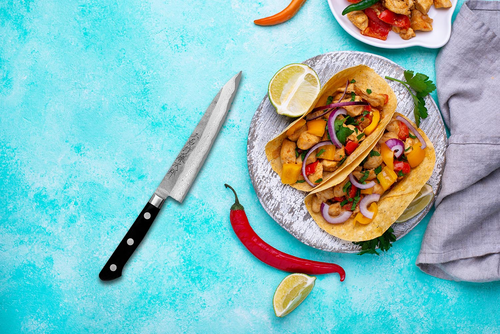 Japoński nóż Shotoh Hatsukokoro Atelier Tomoo Matsumura na tle smacznych tacos.