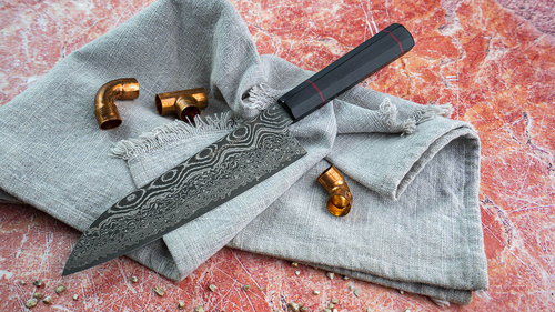 Japoński nóż Santoku Kanetsune Namishibuki na szarej tkaninie