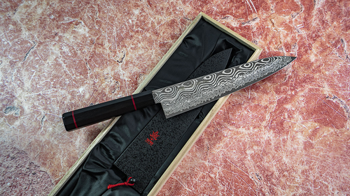 Japoński nóż Gyuto Namishibuki Kanetsune w eleganckim etui na marmurowym tle