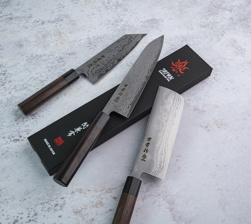 Japoński nóż Santoku Zen-Bokashi Kanetsune, stal Aogami 2, 16,5 cm, na tle kamiennego blatu.