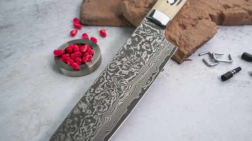 Nóż Takeshi Saji Gyuto WBB R2, 21 cm z damasceńskiej stali na tle kuchennym.