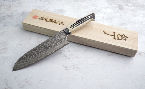 Nóż Santoku Takeshi Saji, 18 cm, 61 warstw R2, na tle drewnianego pudełka.