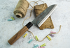 Japoński nóż Santoku Iron Kurouchi Sakai Takayuki na tle kuchennym