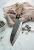 Japoński nóż Santoku Sakai Takayuki Iron Kurouchi na tkaninie z kulkami stalowymi