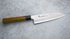 Japoński nóż Santoku Sakai Takayuki Urushi 17 cm na kamiennym tle