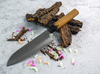 Nóż Santoku Sakai Takayuki Urushi Kokushin na tle kory i kolorowych elementów