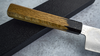 Japoński nóż Gyutoh 24 cm Sakai Takayuki Urushi na tle kuchennym.