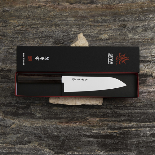Japoński nóż Santoku Ichizu Kanetsune w eleganckim opakowaniu na kamiennej powierzchni.