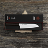 Japoński nóż Santoku Ichizu Kanetsune w eleganckim opakowaniu na kamiennej powierzchni.