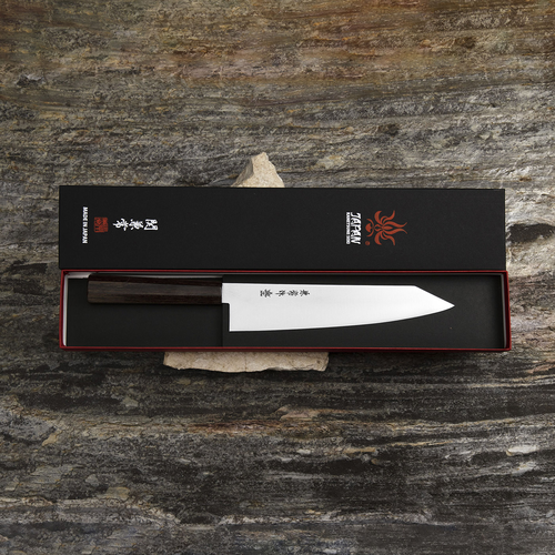 Japoński nóż szefa kuchni Kanetsune Ichizu Kiritsuke 21 cm na tle kamienia
