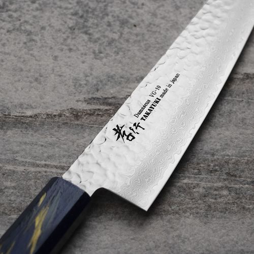 Nóż kuchenny Gyutoh 21 cm Sakai Takayuki Urushi Saiseki na kamiennym tle.