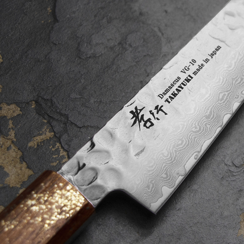 Japoński nóż uniwersalny Urushi Sakai Takayuki Shotoh 15 cm na kamiennej powierzchni.