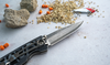 Składany nóż Mcusta Classic Wave Blue Micarta na kamiennym tle