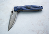 Japoński nóż składany Mcusta Sengoku Blue Pakka Damascus na jasnym tle