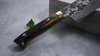 Nóż Nakiri Takeshi Saji YBB VG-10 na tle kamienia, uchwyt z drewna, ostrze 61-warstwowe.
