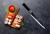 Japoński nóż do sushi Haiku Kurouchi Tosa na tle zestawu sashimi.