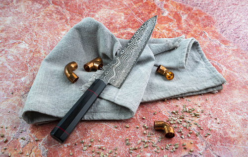 Japoński nóż Kiritsuke Kanetsune z serii Namishibuki na tle jasnej tkaniny