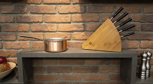 Miedziany rondelek AvantGarde Falk na półce z ceglaną ścianą w tle.