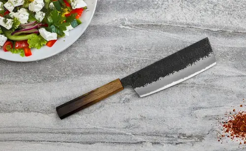 Nóż Sakai Takayuki Homura Guren Nakiri na marmurowym tle z sałatką