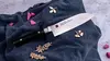 Unikatowy nóż Santoku Kasumi Masterpiece 13 cm na tkaninie z ozdobnymi elementami