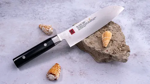Unikatowy nóż Santoku Kasumi Masterpiece VG-10 GOLD na kamieniu z muszlami.