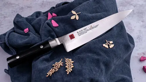 Nóż Gyuto Kasumi Masterpiece VG-10 GOLD, 20 cm, 32 warstwy, na tle granatowej tkaniny.