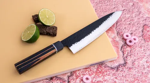 Nóż Gyuto z kolekcji Senzo Finest Suncraft na desce z limonką
