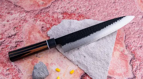 Japoński nóż kucharza Gyuto 21 cm Suncraft Senzo Finest na kamiennym tle.