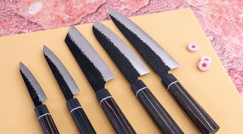 Japoński nóż kuchenny Gyuto Suncraft Senzo na tle deski.