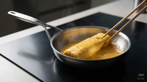 Stalowa patelnia Demeyere 5-PLUS z Silvinox® podczas smażenia omletu na kuchence.