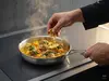 Stalowa patelnia Demeyere 5-PLUS z potrawą na kuchence indukcyjnej