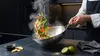 Stalowy wok Demeyere 5-Plus z warzywami w ruchu