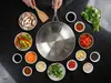 Wok Demeyere 5-PLUS stalowy z technologią 5-Ply, otoczony składnikami na czarnym blacie.