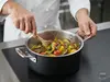 Garnek Demeyere Black 5 z warzywami w kuchni, stalowo-ceramiczna jakość.