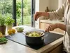 Stalowo-ceramiczny garnek Demeyere Black 5 w kuchni podczas gotowania.
