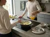 Stalowo-ceramiczna patelnia Black 5 Demeyere na kuchennym blacie z przygotowywanym daniem.