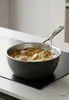 Stalowo-ceramiczna patelnia sauté Demeyere Black 5 z technologią 5-Ply, Ø 20 cm, z daniem.