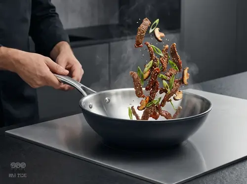 Stalowo-ceramiczny wok Demeyere Black 5 z potrawą w trakcie smażenia na kuchence.