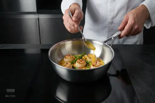 Patelnia sauté Demeyere Atlantis, stalowa, Ø 22 cm, z potrawą na kuchence.