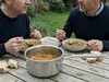 Stalowy rondel Demeyere Industry na stole z zupą warzywną.