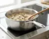 Stalowa patelnia sauté Demeyere Industry, 5-Ply, Ø 18 cm, na kuchence, gotująca risotto.