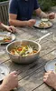 Stalowa patelnia sauté Demeyere Industry z warzywami na drewnianym stole.