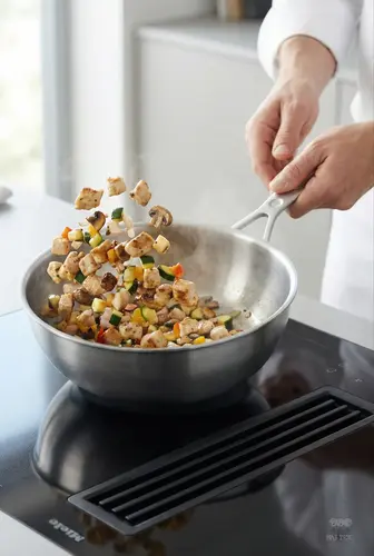 Stalowa patelnia sauté Demeyere Industry z warzywami, Ø 18 cm, idealna do smażenia.