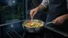 Stalowa patelnia sauté Demeyere Industry z warzywami na kuchence.