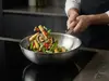 Stalowy wok Demeyere Specialities z warzywami na kuchence